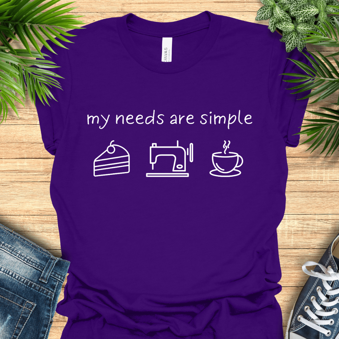 Funny sewing t-shirt with the phrase ‘my needs are simple’ and icons of cake, a sewing machine, and a cup of tea/coffee.