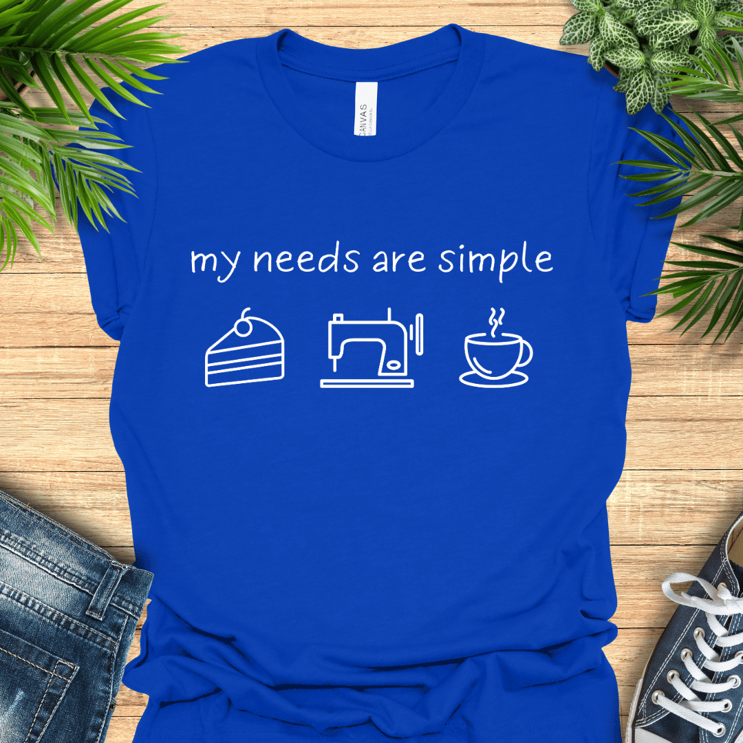 Funny sewing t-shirt with the phrase ‘my needs are simple’ and icons of cake, a sewing machine, and a cup of tea/coffee.