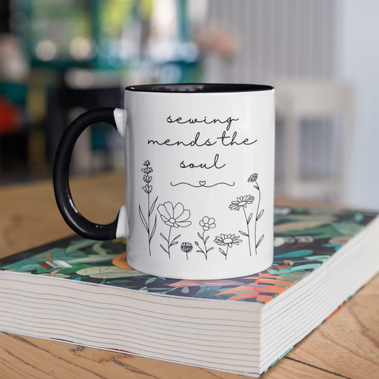 Mug with 'sewing mends the soul' text and floral designs on a book.  Gift for sewers.